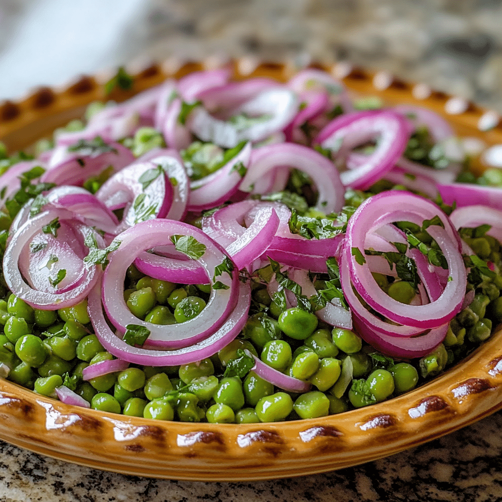 Homemade pea salad with red onions in a serving dish in a bright kitchen