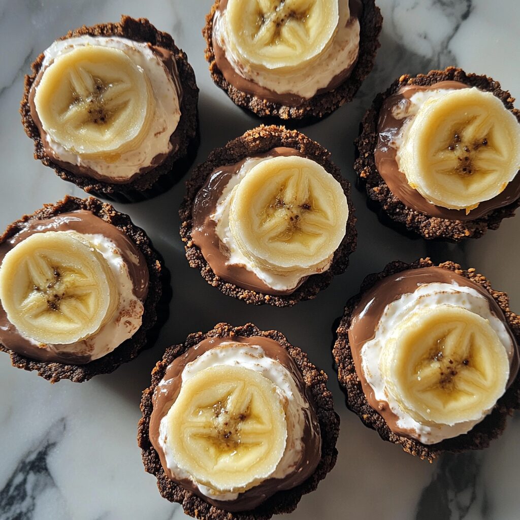 Mini 5-Layer Chocolate Banana Pudding Pie showing layered pudding, bananas, chocolate crust, and whipped topping